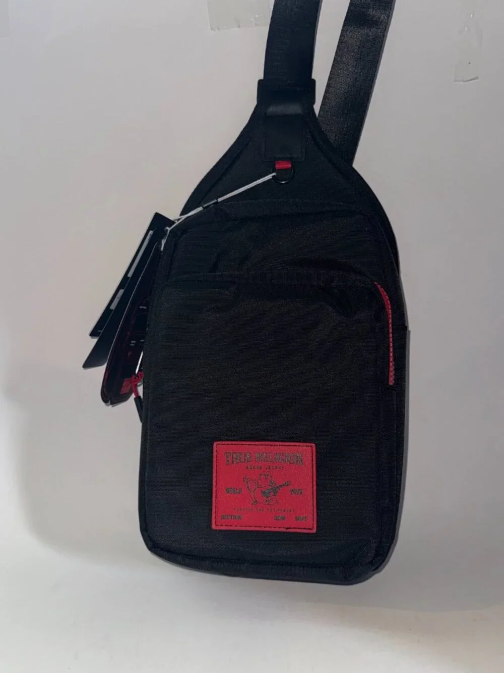 True Religion Sling Bag Features a Textured Brand Patch Durable Nylon With Red